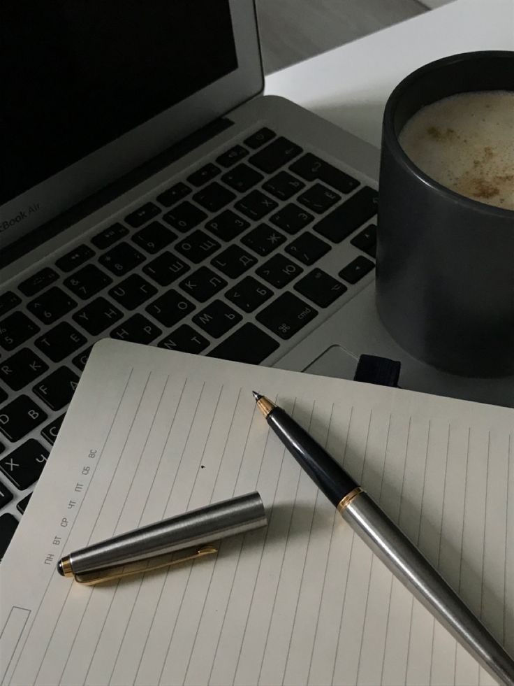 Professional digital marketing workspace with laptop, notebook, pen, and coffee representing productivity, creativity, and digital strategy.